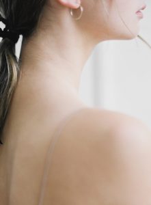 profile of young woman with bare shoulders and long neck