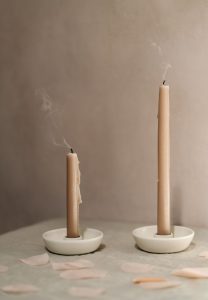 two natural candle sticks blown out with smoke flowing from them